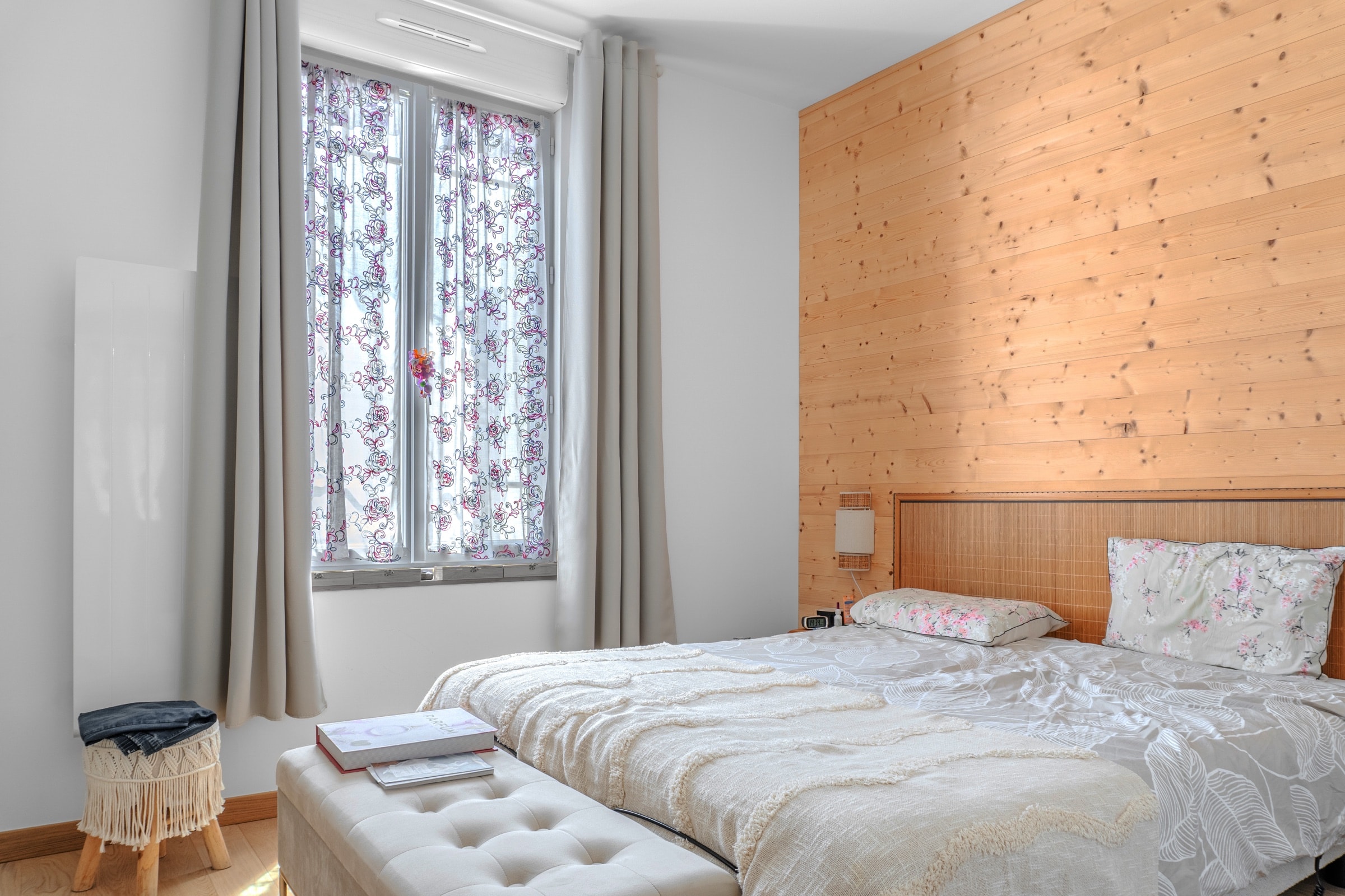 Chambre à la tête de lit en bois clair, lumière du matin