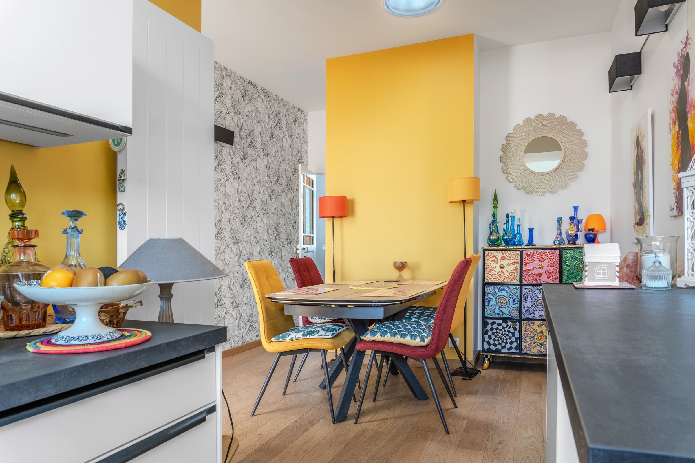 Salle à manger colorée, mur d'accent jaune et mobilier dépareillé