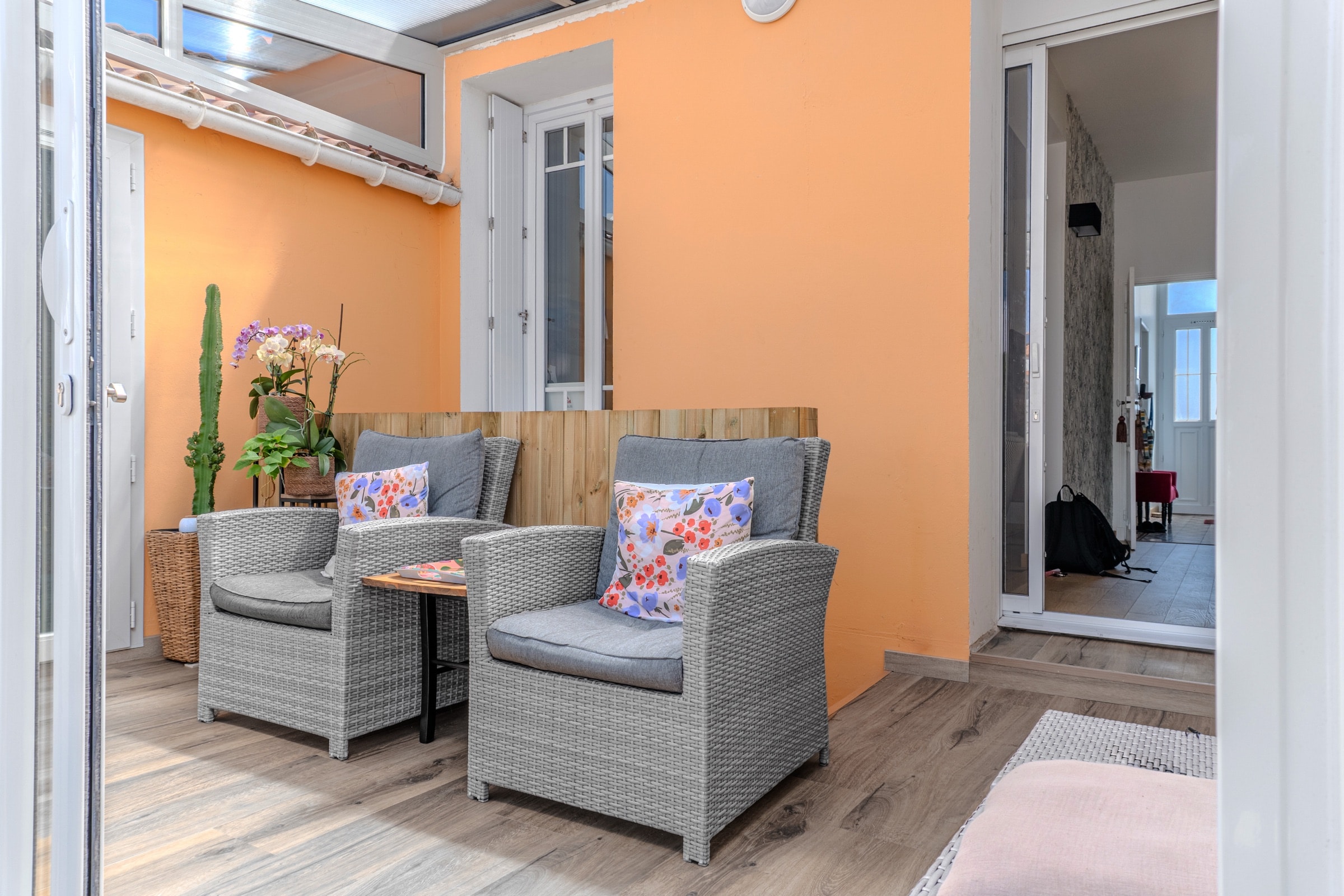Terrasse couverte aux murs terracotta, assises en fibres tressées
